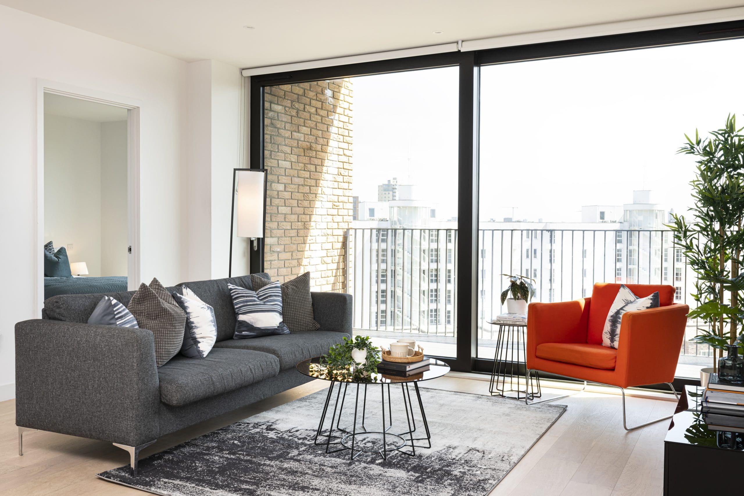 Living space with an outdoor balcony overlooking the city at the Royal Wharf development.